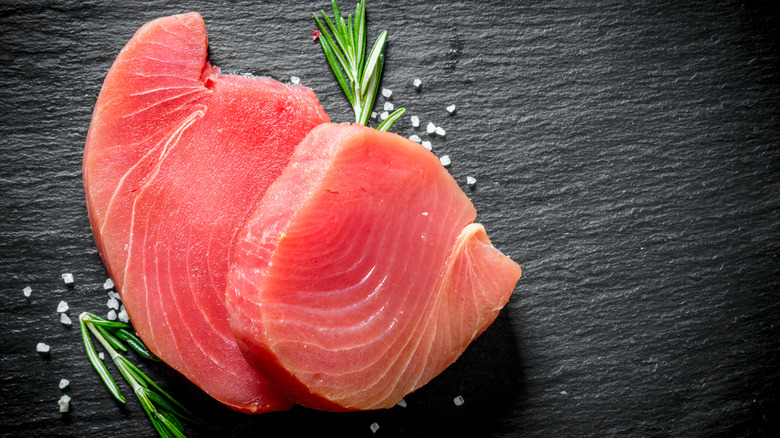 raw tuna steaks on black background