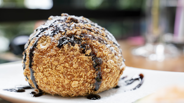 fried ice cream topped with chocolate sauce on a plate