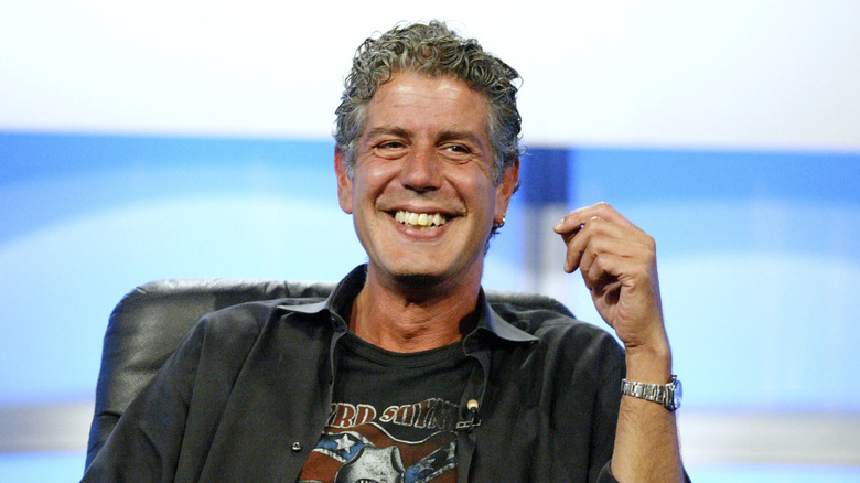Anthony Bourdain sitting and smiling