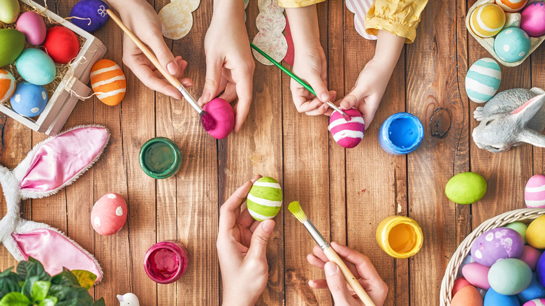 family decorating painted Easter eggs