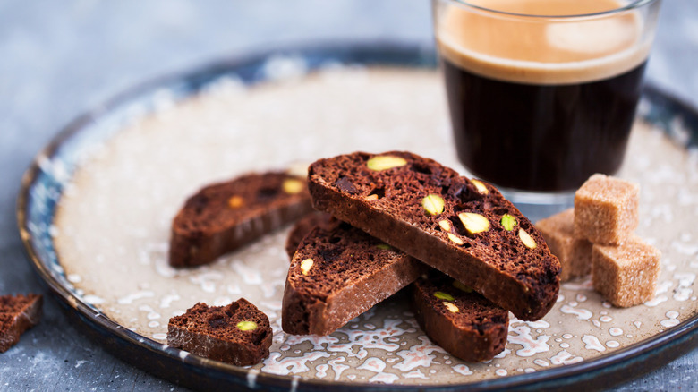 chocolate almond biscotti on a blue plate with a shot of espresso