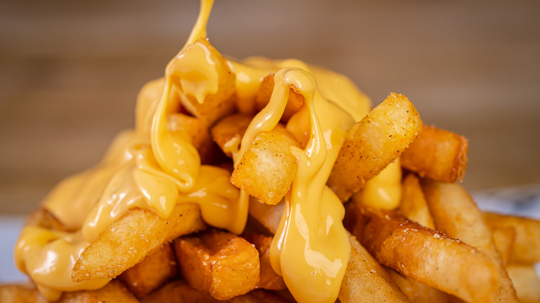 Melted queso cheese pouring on french fries