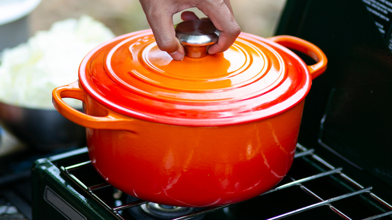 Orange dutch oven on outdoor grill rack