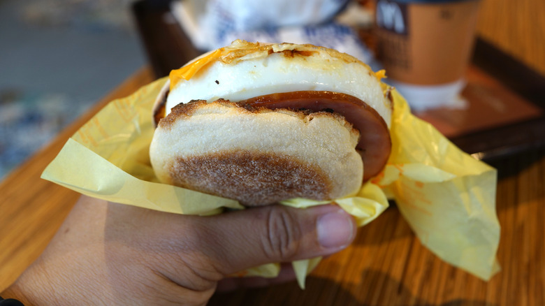 hand holding McDonald's Egg McMuffin