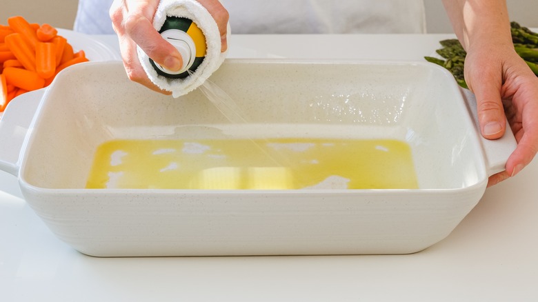 spraying oil into a casserole dish