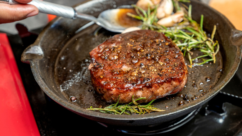 Pan-fried burger with rosemary sprigs
