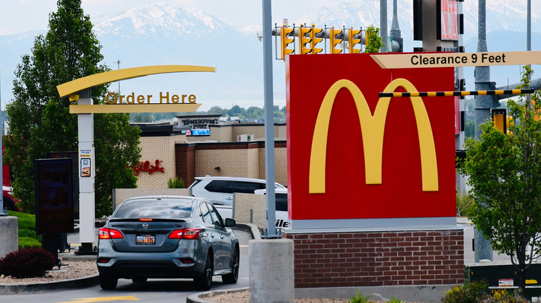 A McDonald's drive-through with cars
