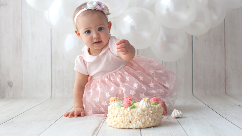 baby sitting with a cake