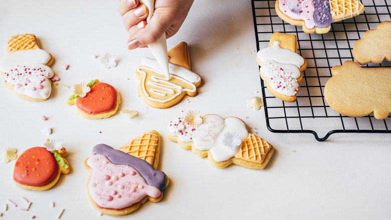 Person decorating assorted cookies