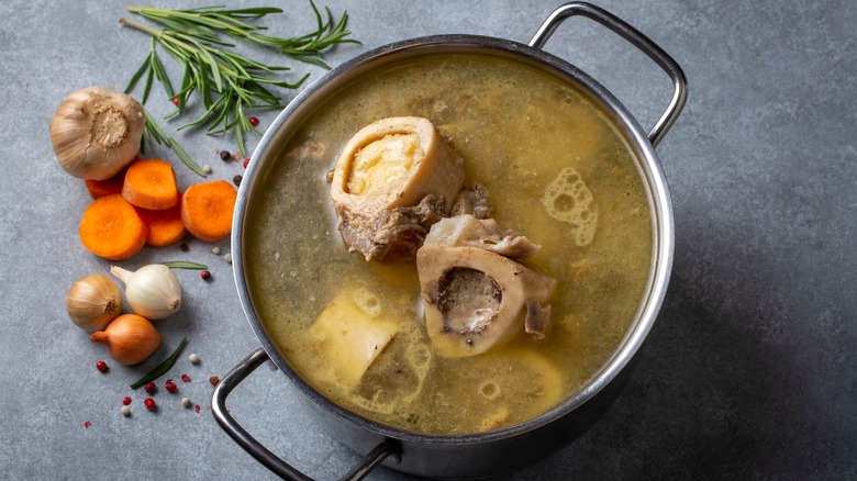 pot of bone broth on counter with veggies