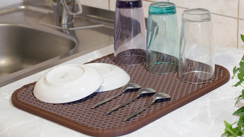 Dishes drying on a mat next to the sink