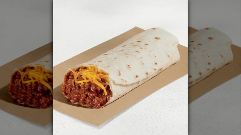 A Taco Bell chili cheese burrito, showing chili and cheese from a cut open end