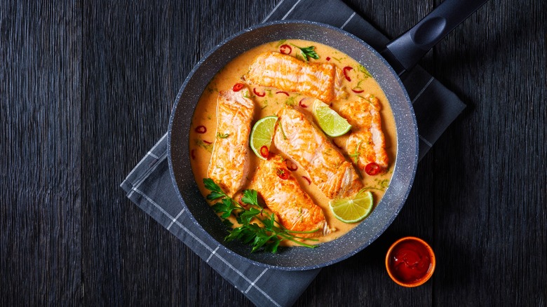 Salmon in orange sauce in pan