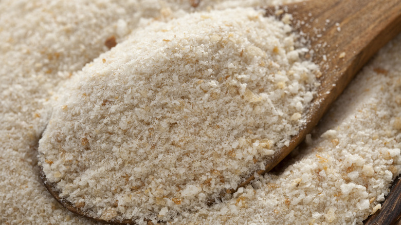 Spoon dipping into breadcrumbs