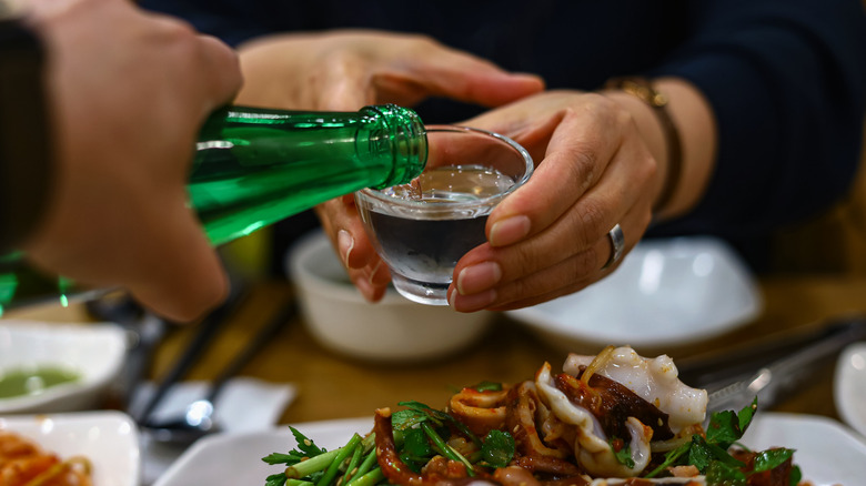 pouring soju into a glass