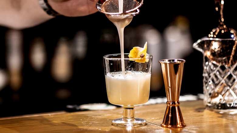 pouring drink into cocktail glass