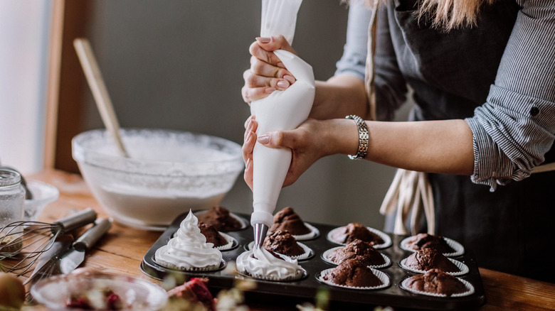 topping cupcakes with homemade whipped cream