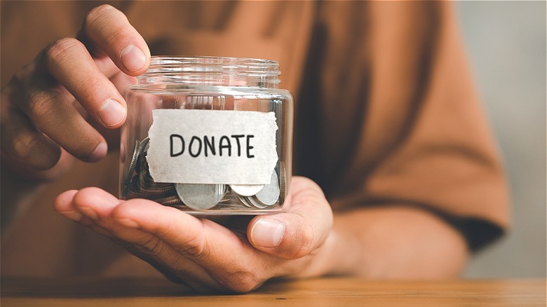 hands holding charity fund jar