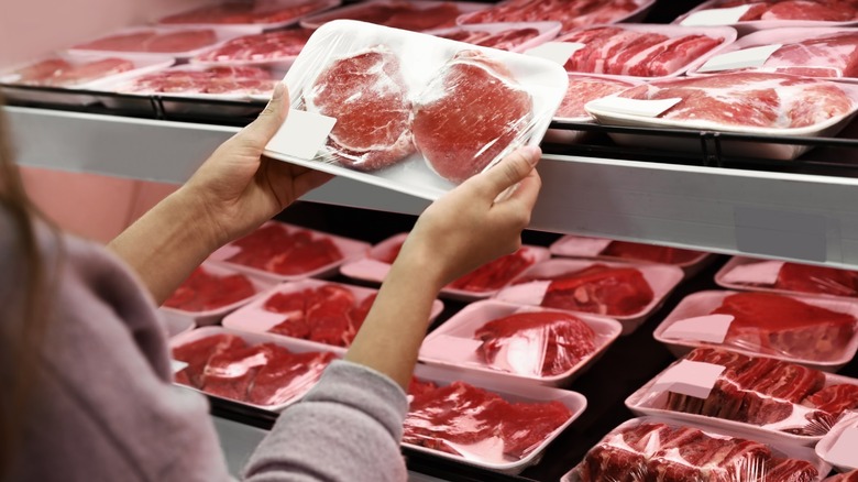 Woman in market meat section