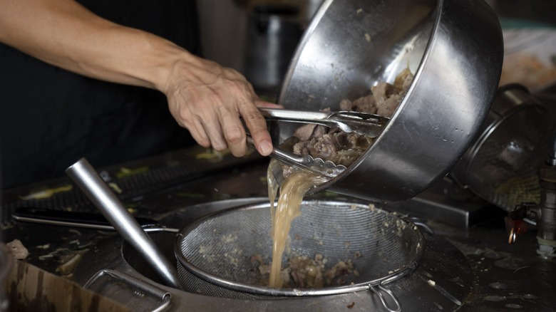 Chef straining broth