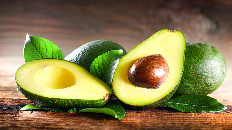Halved avocados on wooden table