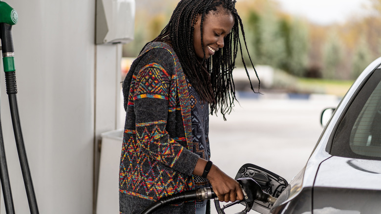 woman pumping gas into car