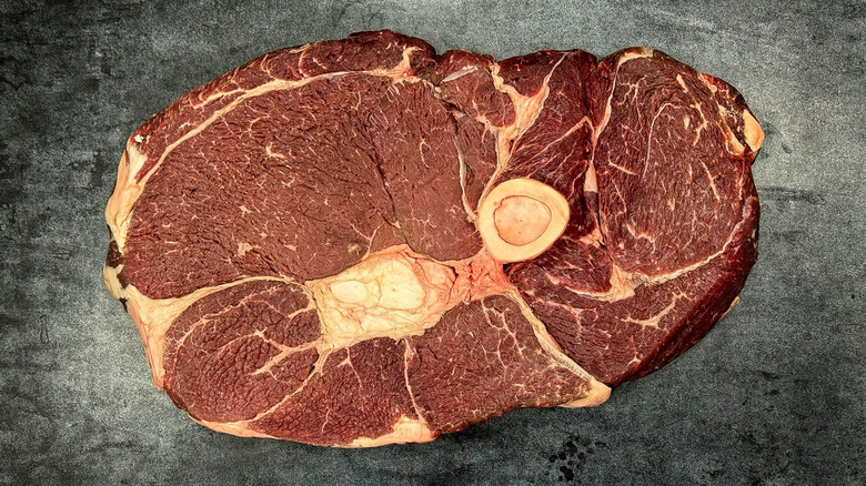 Raw Tom and Jerry steak on charcoal background