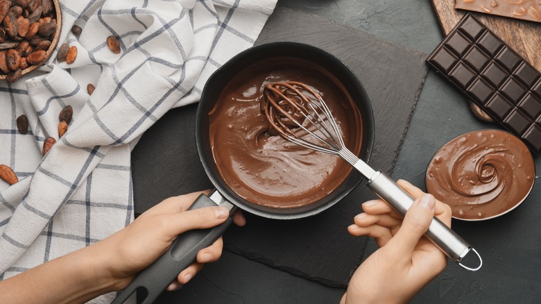 hands stirring pot of chocolate
