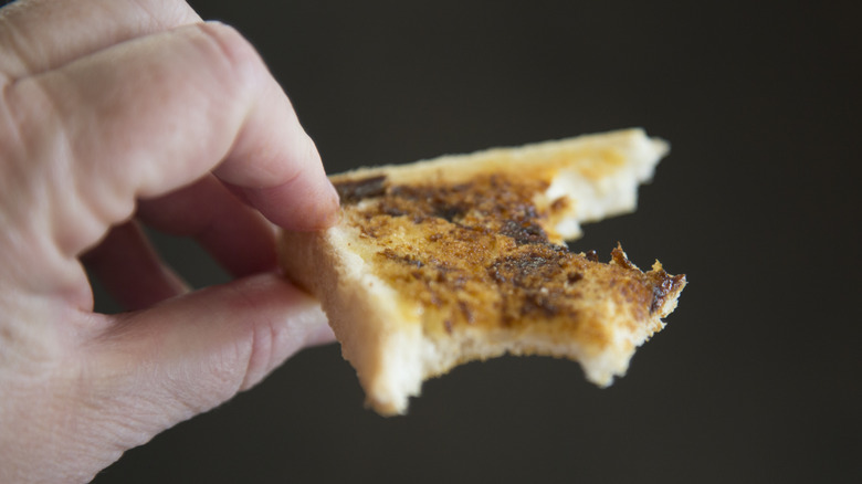 hand holding toast with Marmite