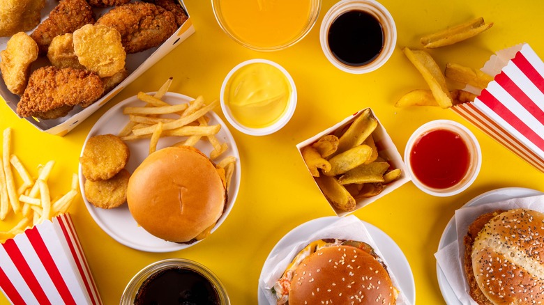 Burgers and fries and other fast food items scattered on a table