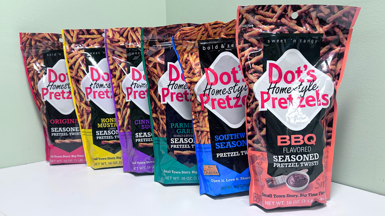 Six bags of Dot's Homestyle Pretzels lined up together against a green and white background