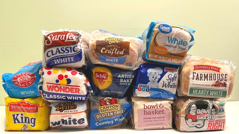 Many loaves of white bread stacked together against a pale background