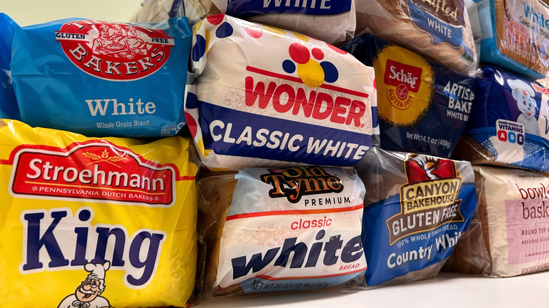 Close up of several white bread brands stacked together