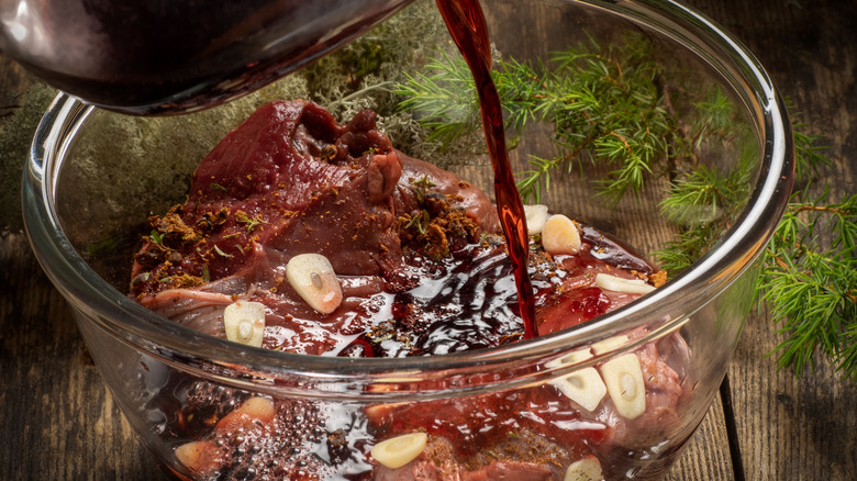 pouring marinade over raw meat