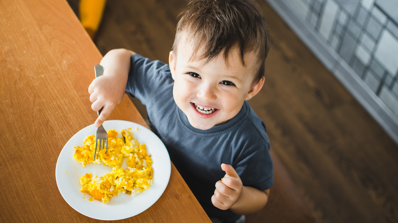 little boy eating scrambled eggs