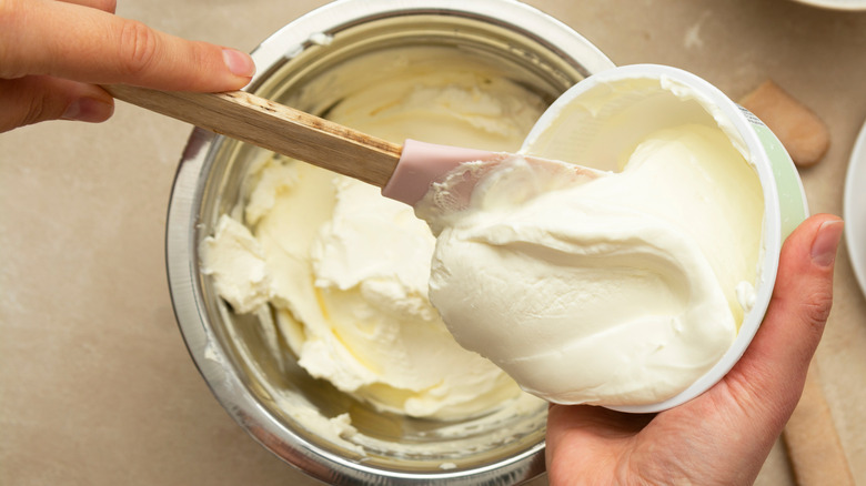 adding sour cream into bowl
