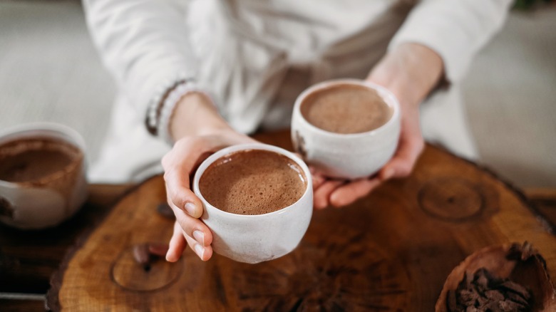 Person with two cups of hot chocolate