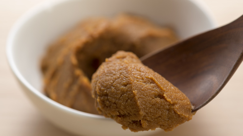 Red miso in white bowl with wooden spoon