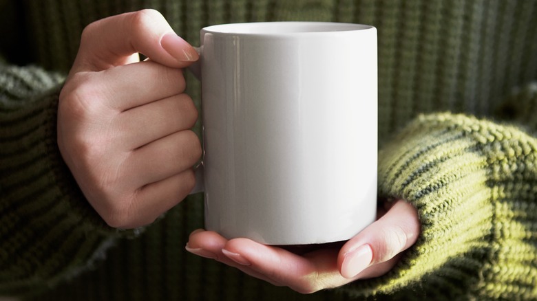 two hands holding mug