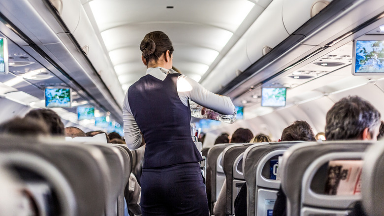 Flight attendant in plane aisle