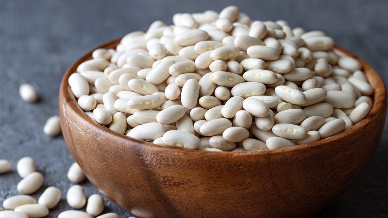 Uncooked beans in wooden bowl