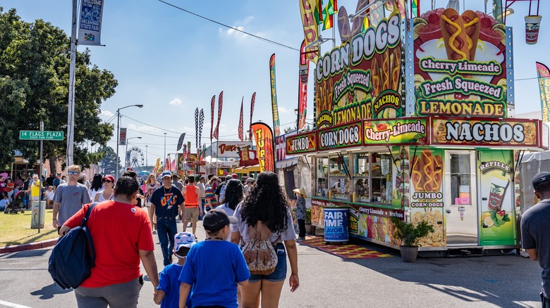 people walking by fair food stands