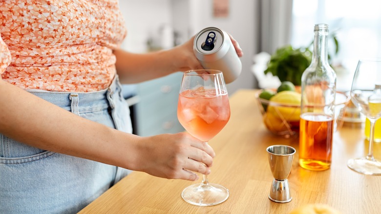 woman pouring mocktail into glass
