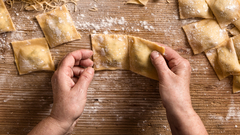 hands forming fresh pasta squares