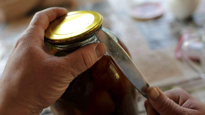 opening a jar with a butter knife