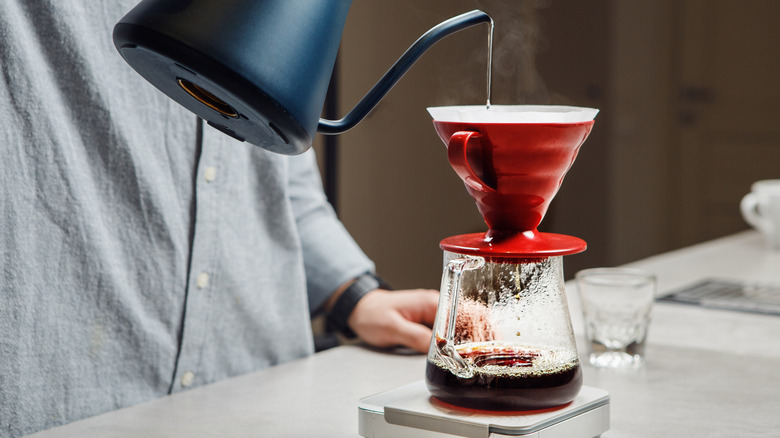 Person pouring coffee from gooseneck kettle