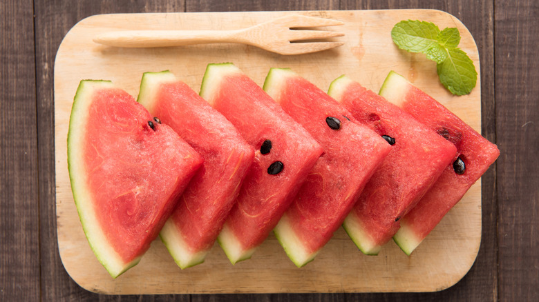 Slices of fresh watermelon on a wooden cutting board