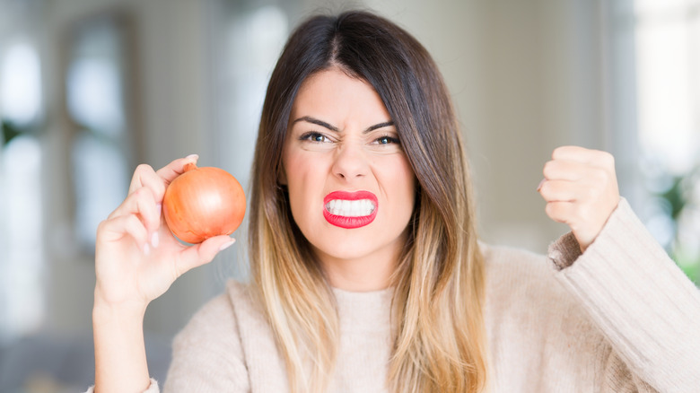Woman angrily holding up an onion