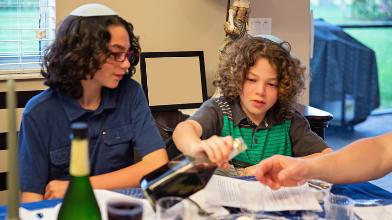 A pair of Jewish children having Seder wine