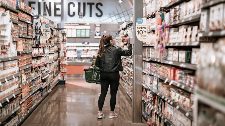 person walking in Whole Foods aisle